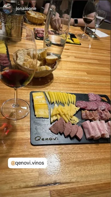 Picada de fiambres y quesos con copa de vino en una cata Qenovi